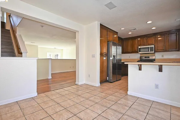 a kitchen view with stainless steel appliances a refrigerator and a stove top oven
