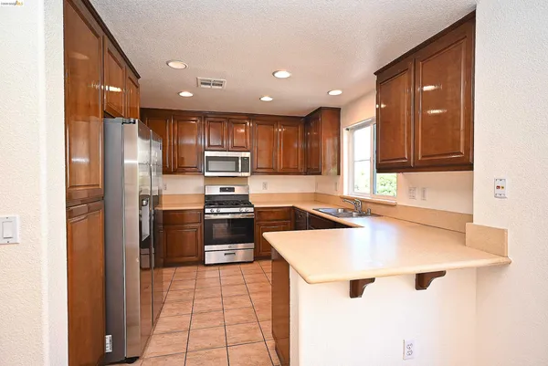 a kitchen with a refrigerator a sink and wooden cabinets