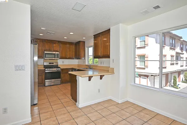a kitchen with granite countertop a refrigerator and a stove top oven