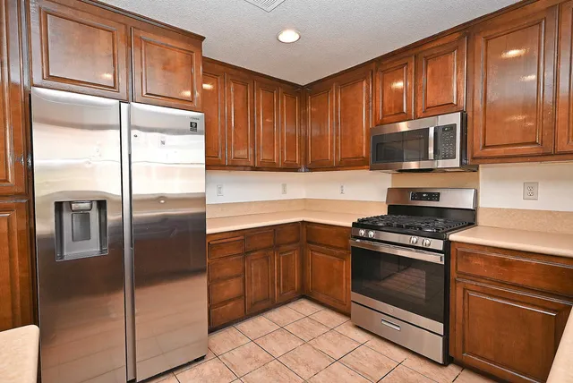 a kitchen with stainless steel appliances granite countertop a refrigerator stove and cabinets