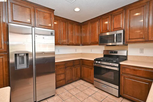 a kitchen with stainless steel appliances granite countertop a refrigerator stove and cabinets