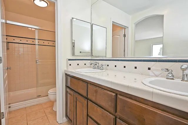 a spacious bathroom with a granite countertop sink mirror and a toilet