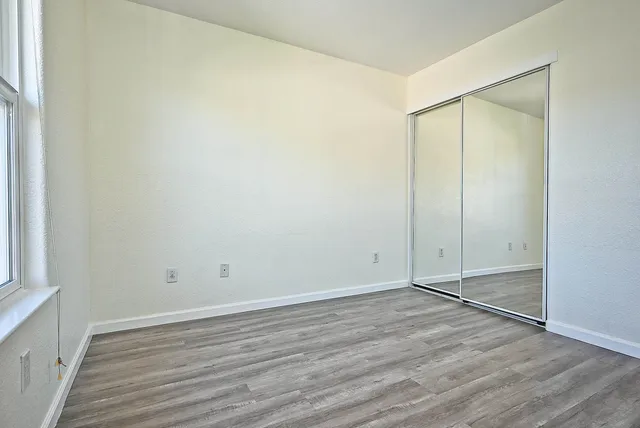a view of an empty room with wooden floor