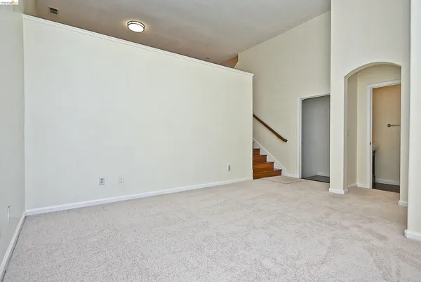 an empty room with a ceiling fan and closet area