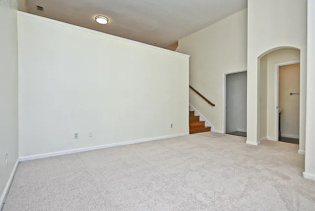 an empty room with a ceiling fan and closet area