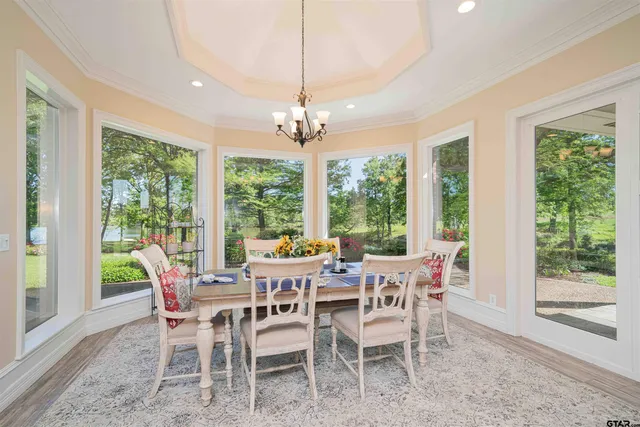 a view of a dining room with furniture large windows and wooden floor