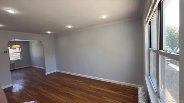 an empty room with wooden floor and a window
