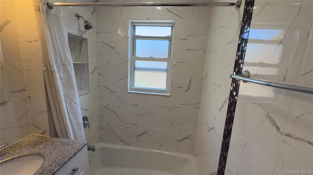 a bathroom with a granite countertop sink a mirror and a shower