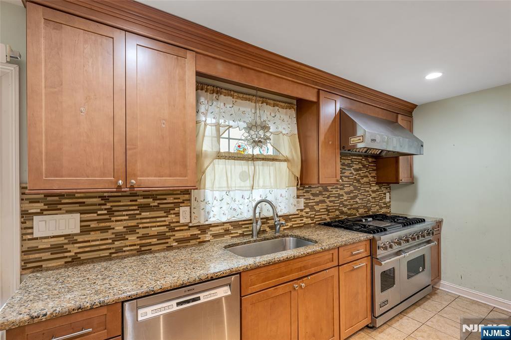 255 Knoll Road Lake Hiawatha, NJ 07034 - Photo 13 of 35 a kitchen with stainless steel appliances granite countertop a sink a stove and a microwave