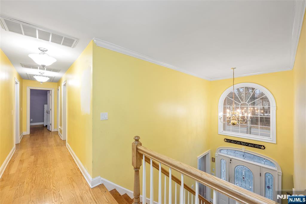255 Knoll Road Lake Hiawatha, NJ 07034 - Photo 23 of 35 a view of a hallway with wooden floor and chandelier