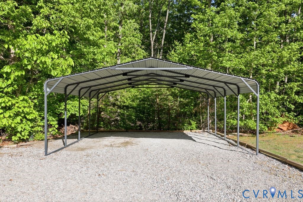 5307 St Pauls Church Road Goochland, VA 23063 - Photo 32 of 44 a backyard of a house with table and chairs under an umbrella
