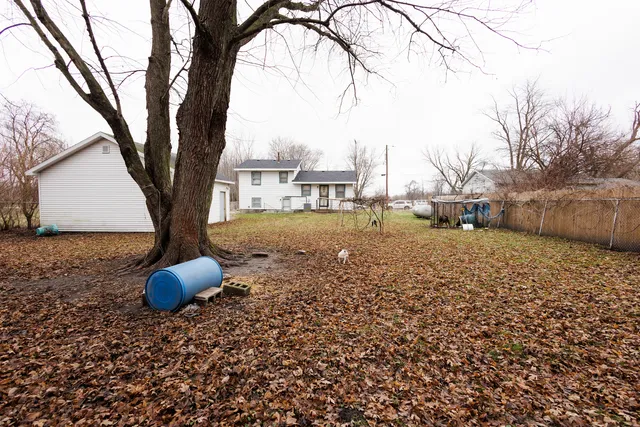a view of a house with backyard and tree