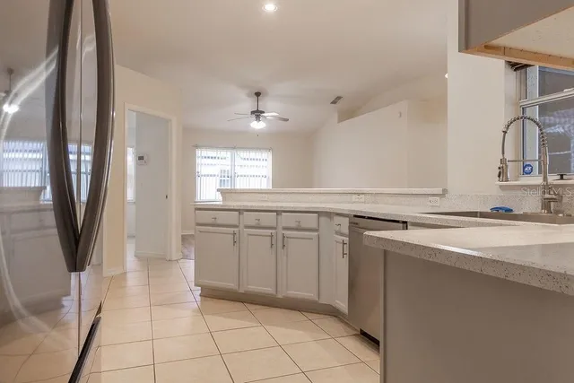 a kitchen with a sink a refrigerator and cabinets