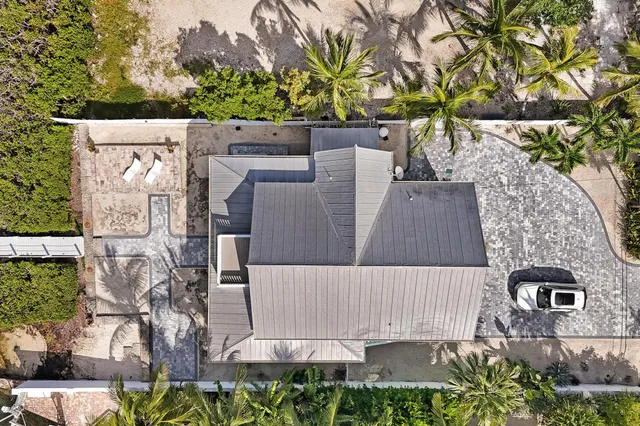 an aerial view of residential house with outdoor space and trees all around