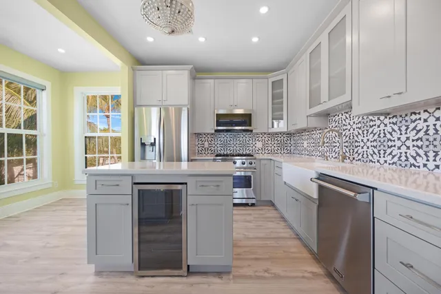 a kitchen with kitchen island granite countertop a sink cabinets and stainless steel appliances