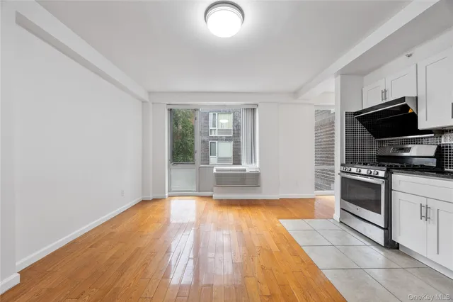 a kitchen with granite countertop a stove and a wooden floors