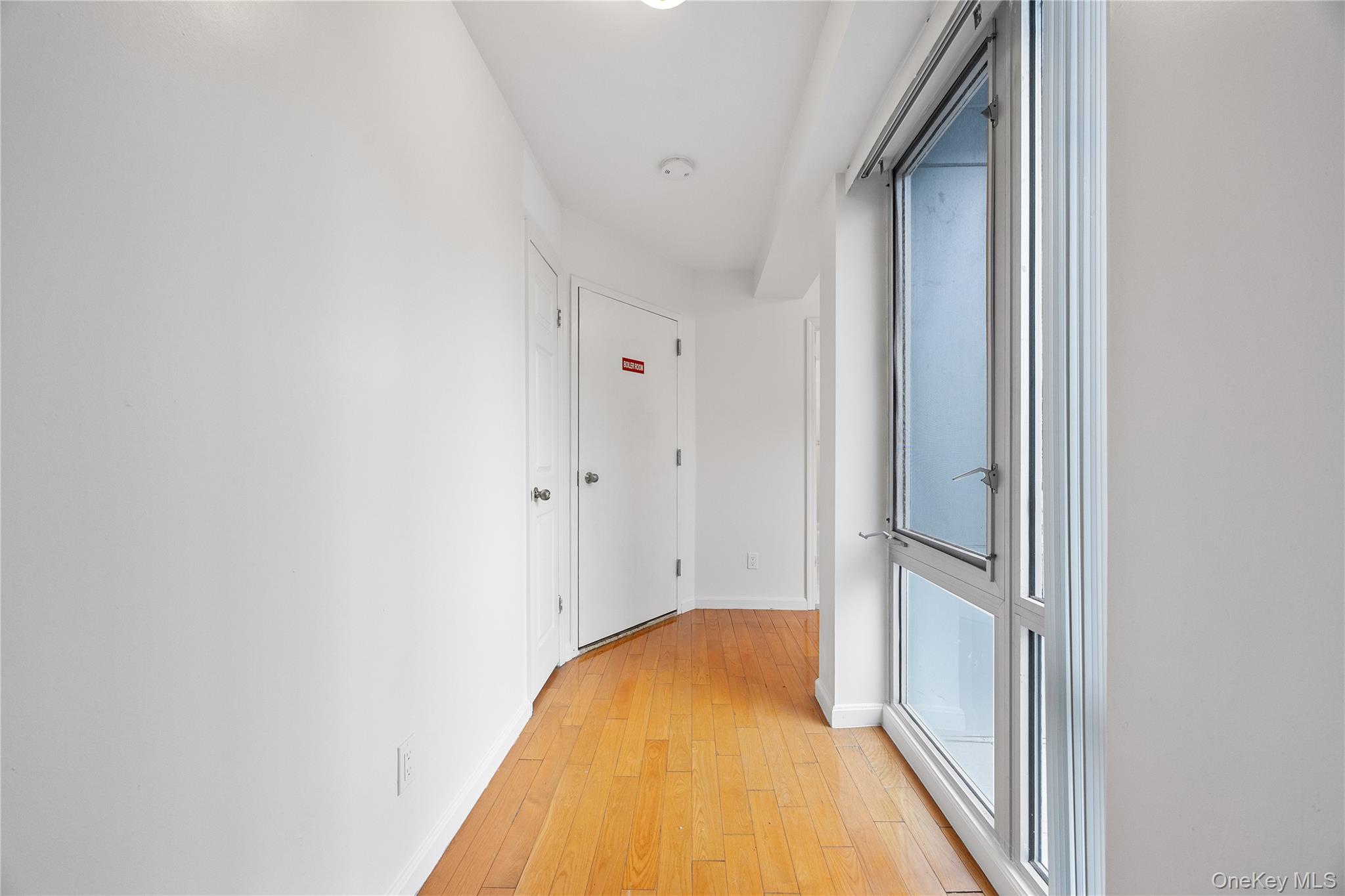 139-30 34th Avenue, Unit 3B Queens, NY 11354 - Photo 4 of 20 a view of a hallway with wooden floor and a bathroom