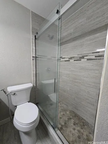 a bathroom with a toilet and a shower