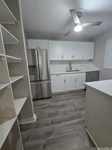 a kitchen with granite countertop a refrigerator and a sink