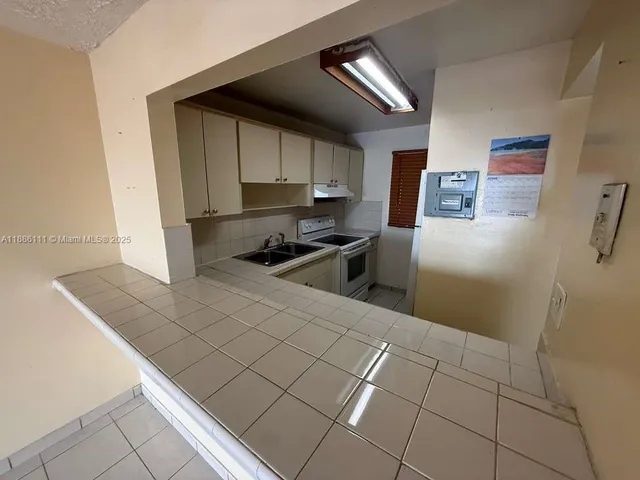 a kitchen with stainless steel appliances a refrigerator a stove a sink and a counter top