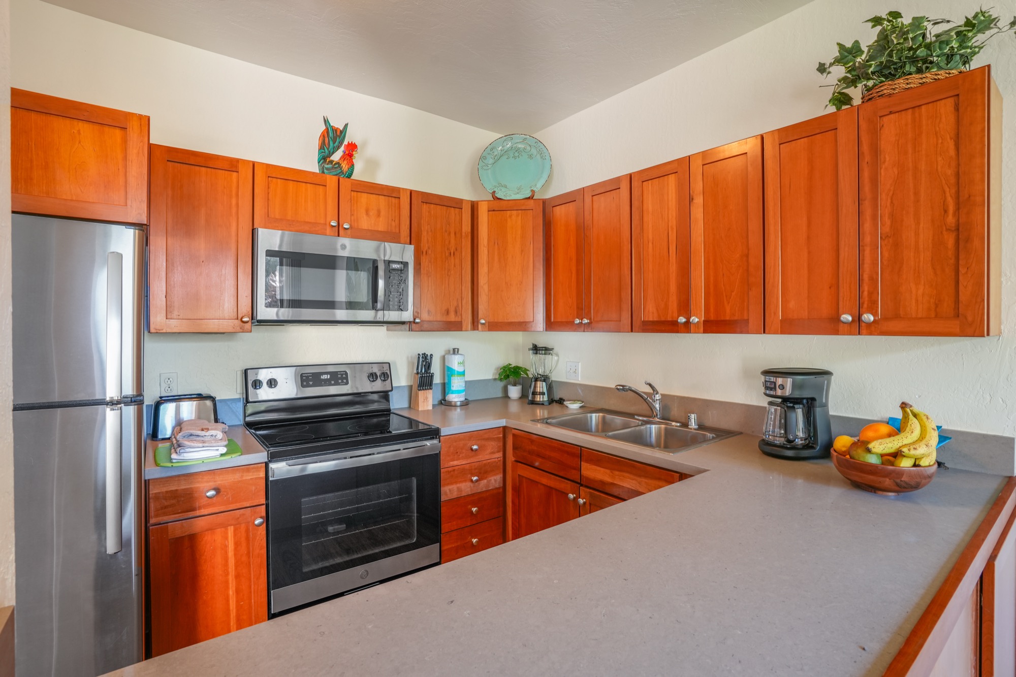 1901 Poipu Road, Unit 112 Koloa, HI 96756 - Photo 8 of 21 a kitchen with stainless steel appliances a stove refrigerator sink and cabinets