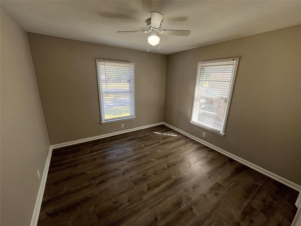 1622 Centerville Road Dallas, TX 75228 - Photo 15 of 19 Wood-finish flooring, two windows with blinds, and a ceiling fan with integrated lighting