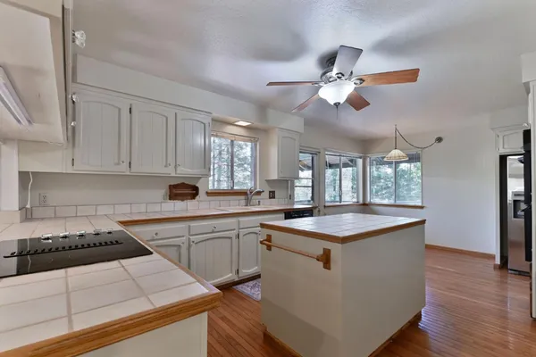 a kitchen with stainless steel appliances kitchen island granite countertop a stove a sink and a refrigerator