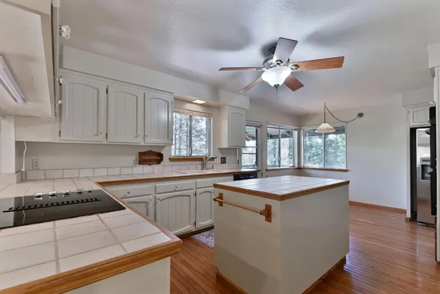 a kitchen with stainless steel appliances kitchen island granite countertop a stove a sink and a refrigerator