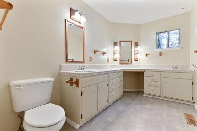 a view of an empty room with wooden floor and window