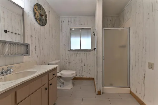a view of a patio with table and chairs under an umbrella with a large tree