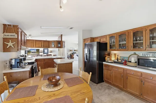 a kitchen with stainless steel appliances granite countertop a refrigerator a stove a sink dishwasher with a dining table and chairs