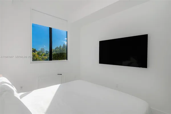 a bedroom with a bed and a flat screen tv