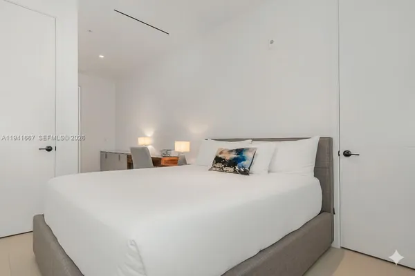 a bedroom with a bed and a night stand