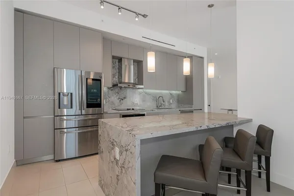 a kitchen with stainless steel appliances granite countertop a sink refrigerator and microwave