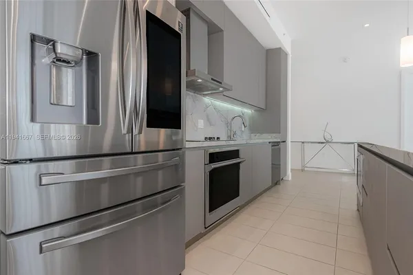 a kitchen with stainless steel appliances granite countertop a refrigerator and a stove