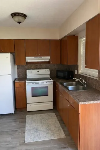 a kitchen with a stove top oven and sink