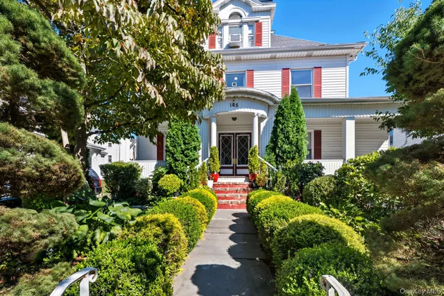 a front view of a house with a yard and potted plants