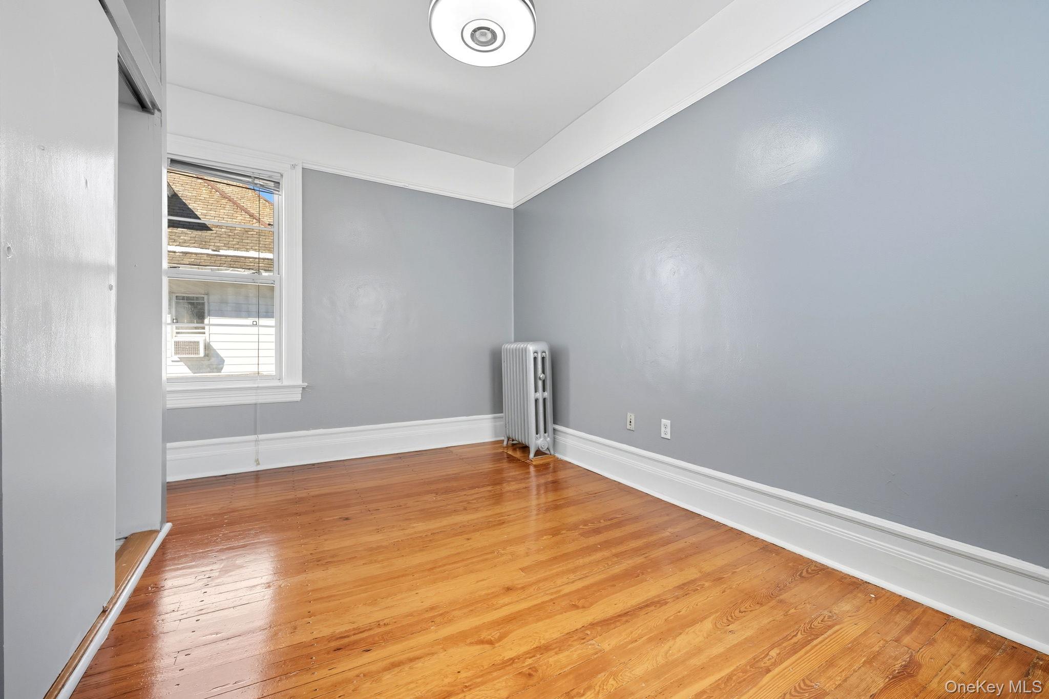 165 Park Avenue, Unit 2 Mount Vernon, NY 10550 - Photo 7 of 20 a view of an empty room with wooden floor and a window