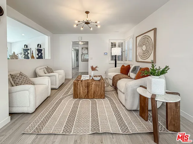 a spacious bedroom with a bed a couch and painting on the wall