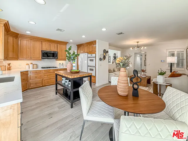 a dining room with stainless steel appliances kitchen island granite countertop a dining table chairs and kitchen view