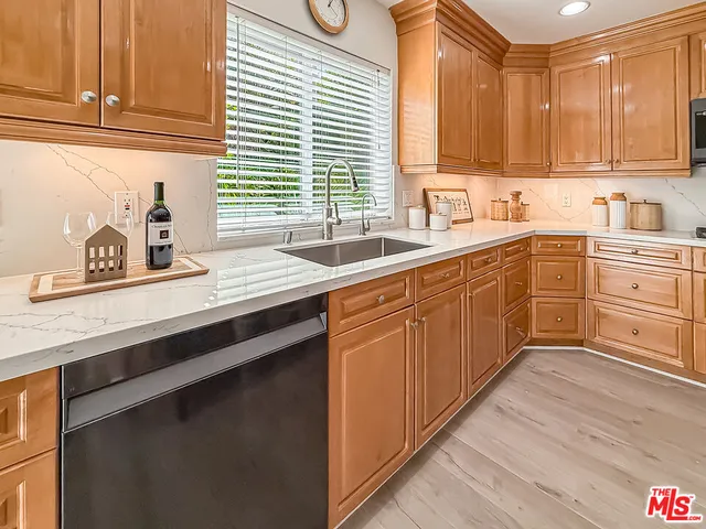 a kitchen with stainless steel appliances granite countertop a sink a stove and cabinets