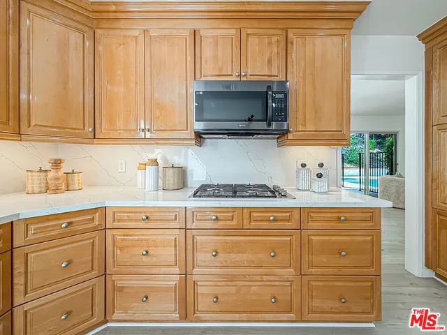a kitchen with granite countertop white cabinets and stainless steel appliances