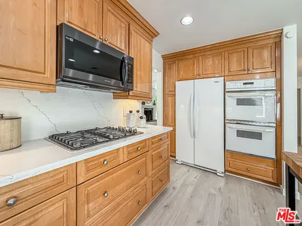 a kitchen with stainless steel appliances a stove microwave and refrigerator