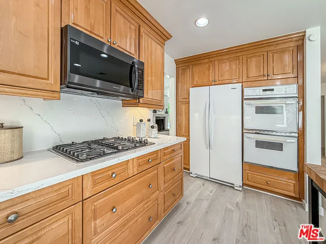 a kitchen with stainless steel appliances a stove microwave and refrigerator