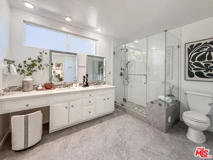 a spacious bathroom with a granite countertop sink mirror and toilet