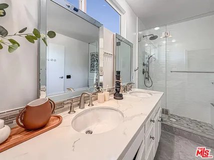 a bathroom with a granite countertop sink and a mirror