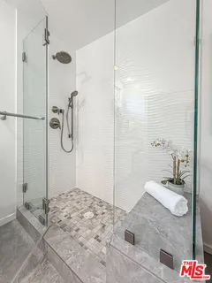 a bathroom with a granite countertop sink a mirror and shower