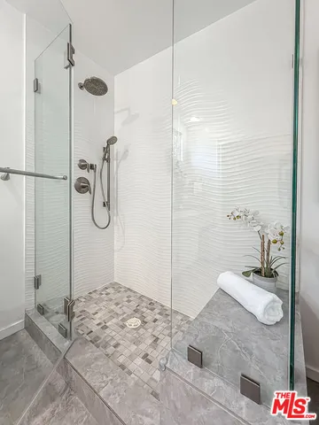 a bathroom with a granite countertop sink a mirror and shower