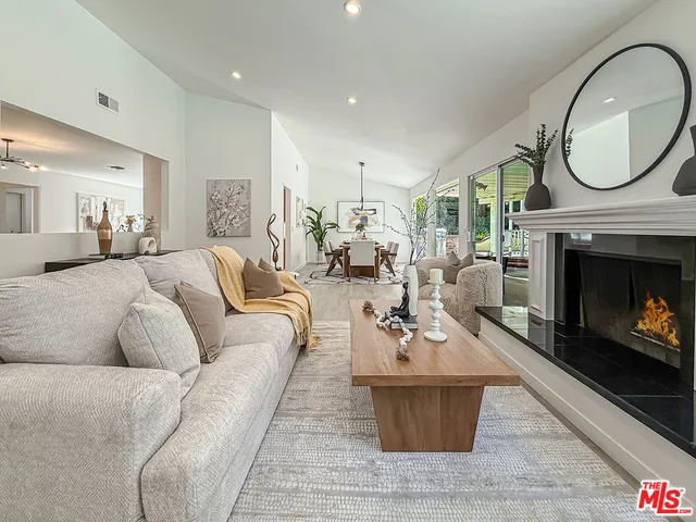 a living room with furniture a fireplace a rug and a window