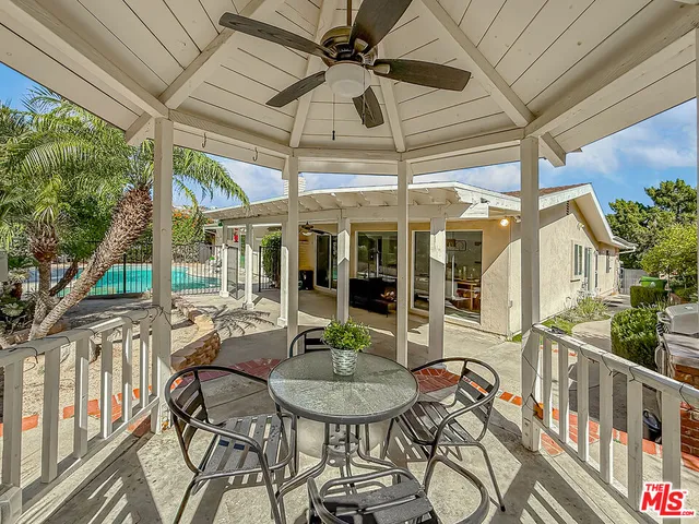 a view of a patio with table and chairs under an umbrella